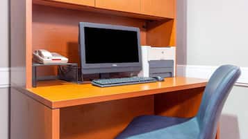 A wooden desk with a computer, keyboard, and mouse.