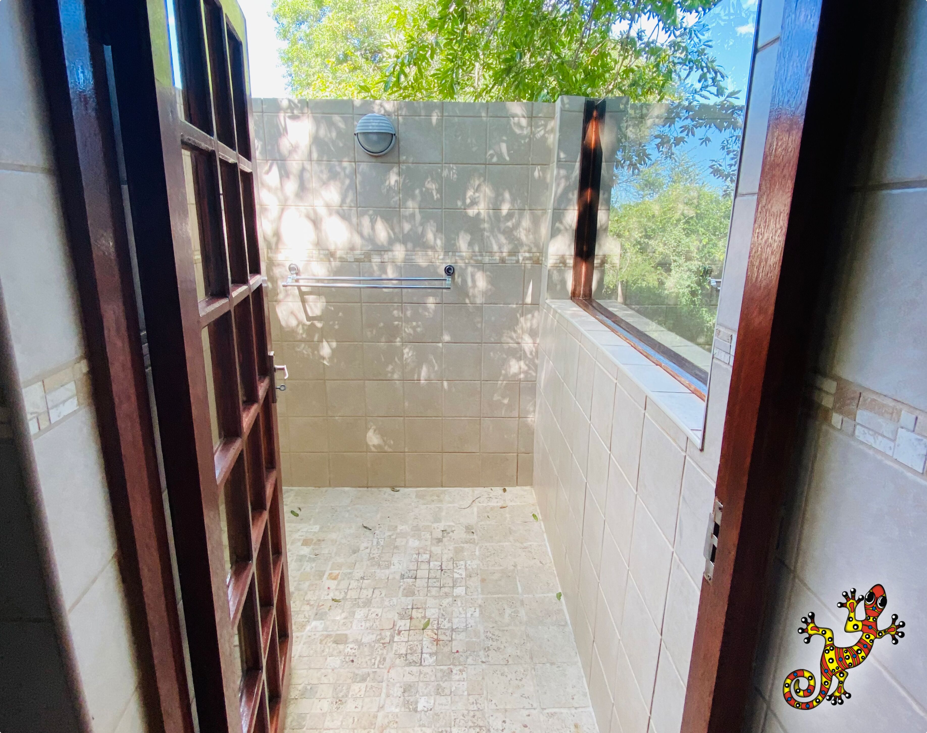 Un baño pequeño con azulejos, una ventana y un perchero para toallas.