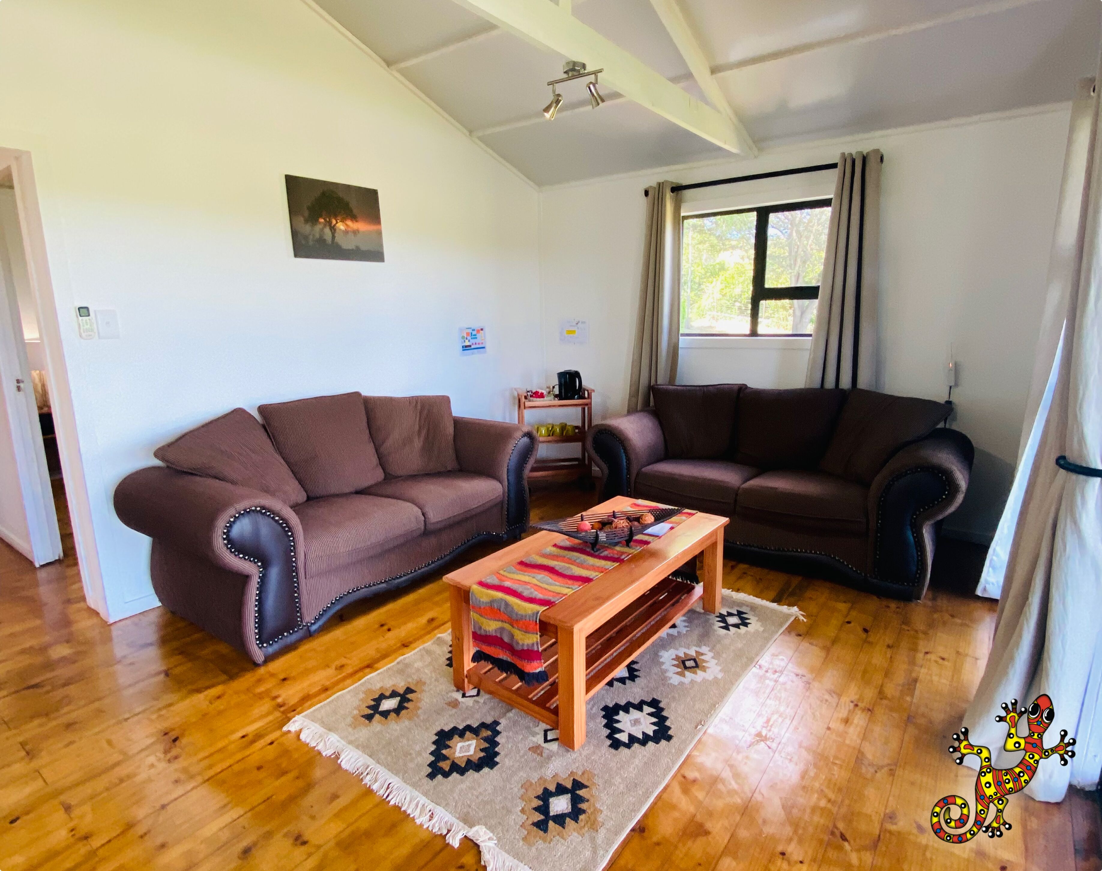 A living room with two sofas, a coffee table, and a patterned rug.