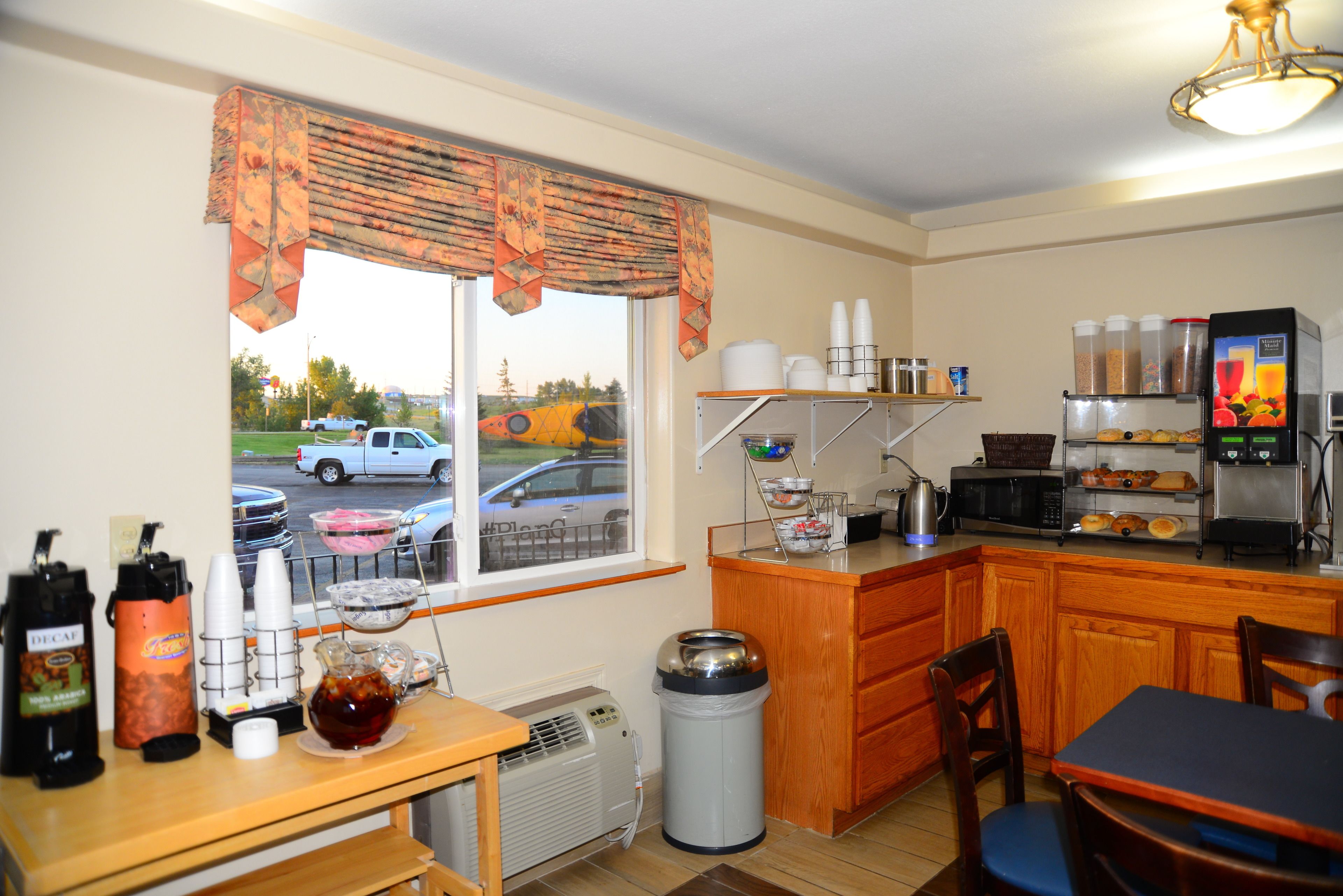 A small kitchen with a window, a coffee station, and a microwave.