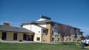 A multi-story hotel with a 'Pool' sign, a 'Budget Inn Express' sign, and a 'Pepsi' sign. - Budget Inn Express (Gillette)