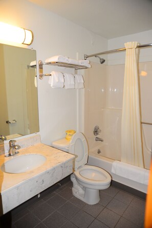A bathroom with a sink, toilet, and shower.