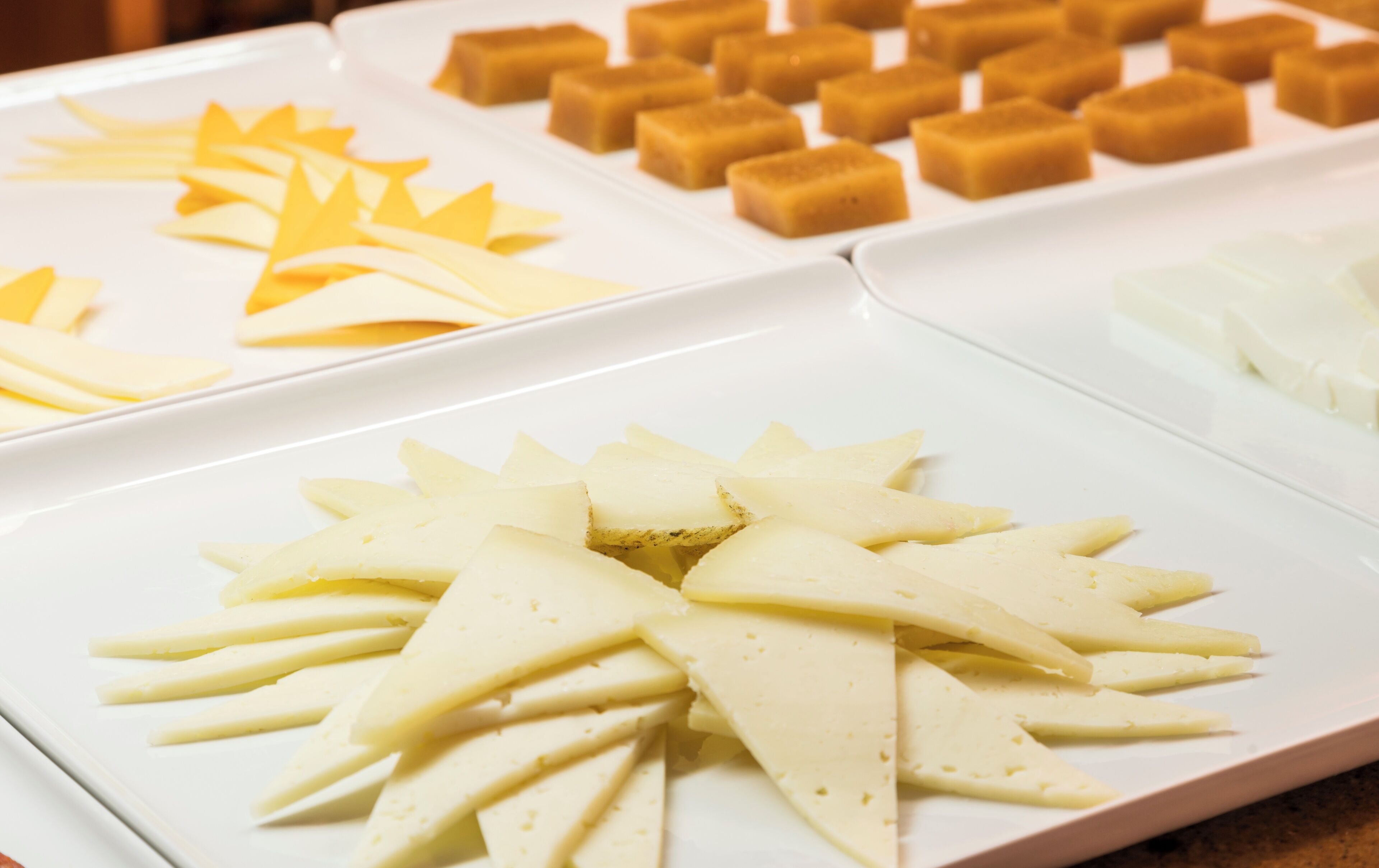 A buffet with various food items including cheese, crackers, and other snacks.