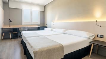 Una habitación de hotel con una cama grande, un escritorio y una silla.