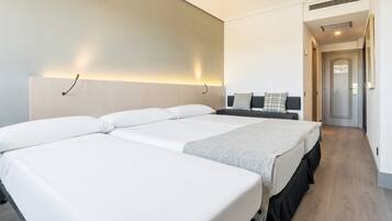 Una habitación de hotel con una cama grande, una mesita de noche y una lámpara de pared.