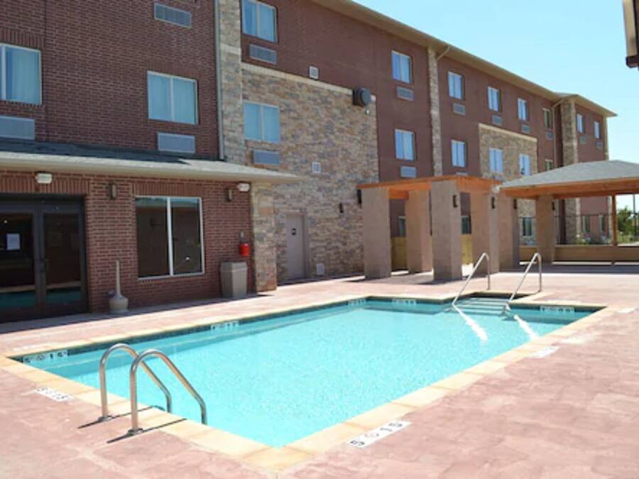 A swimming pool with a brick building in the background.