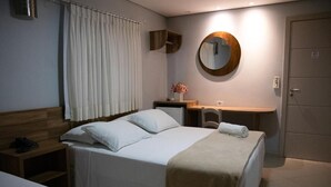 A hotel room with a bed, bedside table, a mirror, and a door. - Maximus Sottile Hotel (Ji Parana)