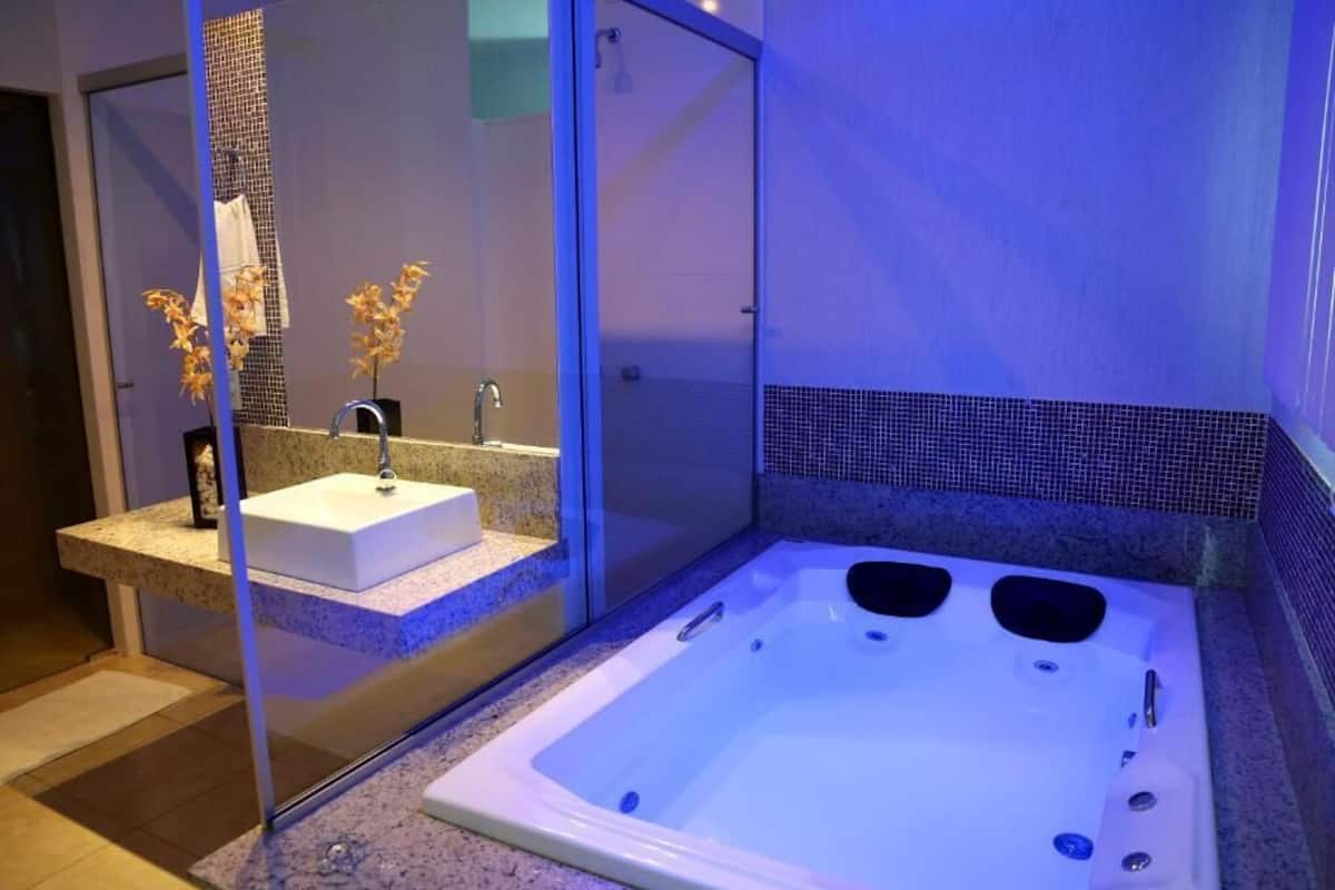 Een moderne badkamer met een douchecabine van glas, een witte wastafel en een ruime badkuip.