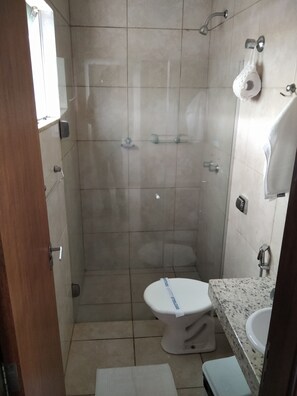 A small bathroom with a toilet, sink, and shower. - Monte Castro Executive Hotel (Araguari)