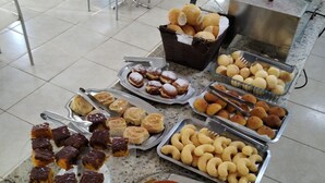 A buffet with various food items including pastries, cakes, and snacks. - Monte Castro Executive Hotel (Araguari)
