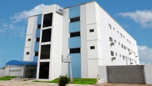 A modern building with a white facade, multiple windows, and a blue awning. - Monte Castro Executive Hotel (Araguari)