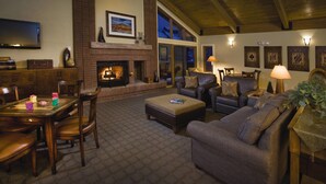 A spacious living room with a fireplace, comfortable seating, a dining area, and large windows. - WorldMark Steamboat Springs (Steamboat Springs)