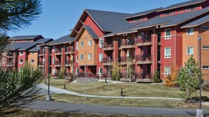 A multi-story residential building with balconies, a flat roof, and a landscaped front yard. - WorldMark Steamboat Springs (Steamboat Springs)