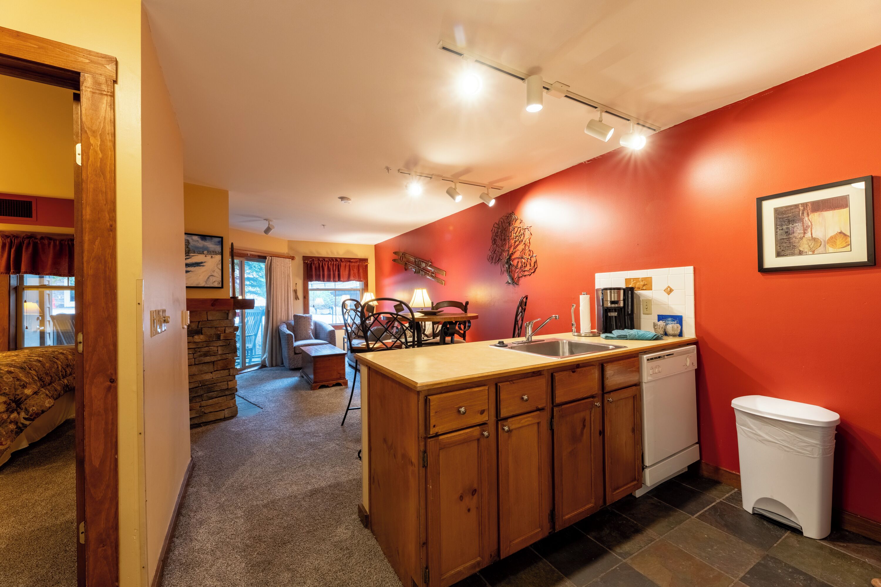 A compact kitchen with wooden cabinets, a sink, and a dishwasher.