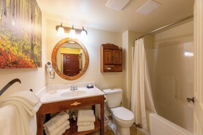 A bathroom with a sink, toilet, and shower.