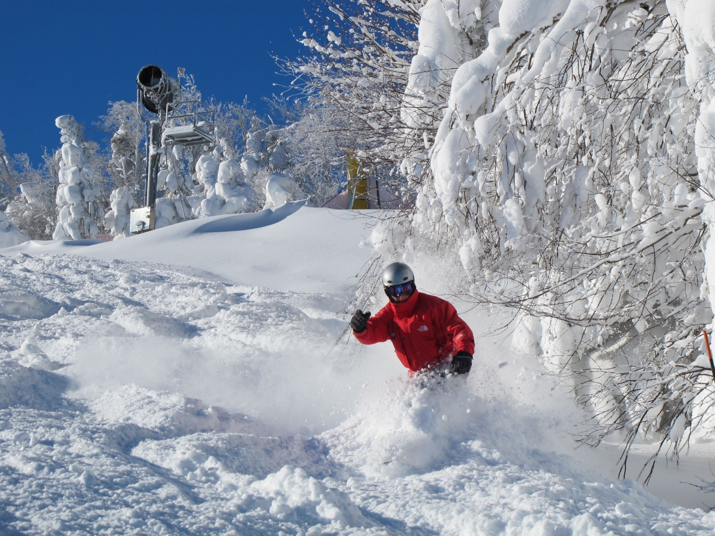 A snowy landscape with a person skiing.