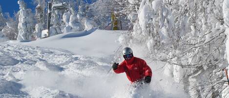 A snowy landscape with a person skiing.