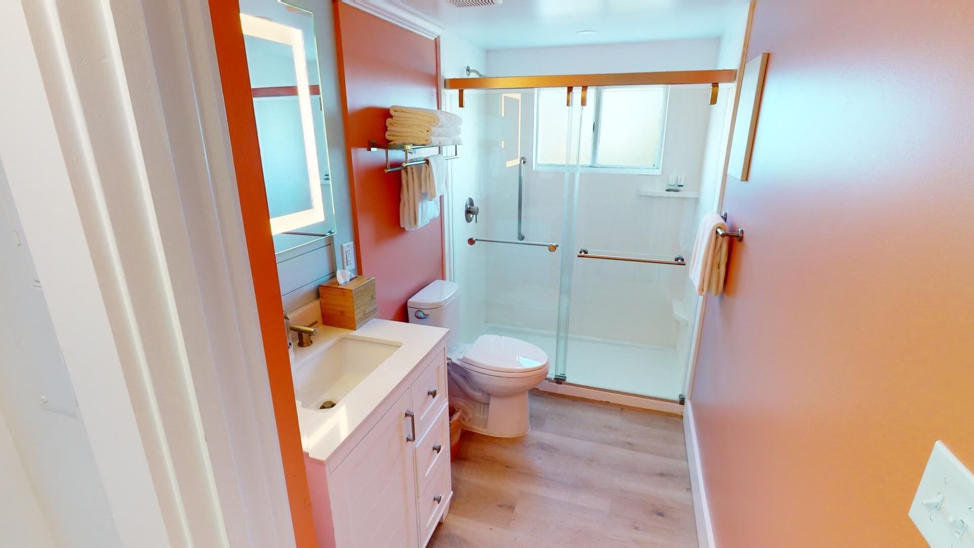 Ein kleines Badezimmer mit Toilette, Waschbecken und einer Duschkabine aus Glas.