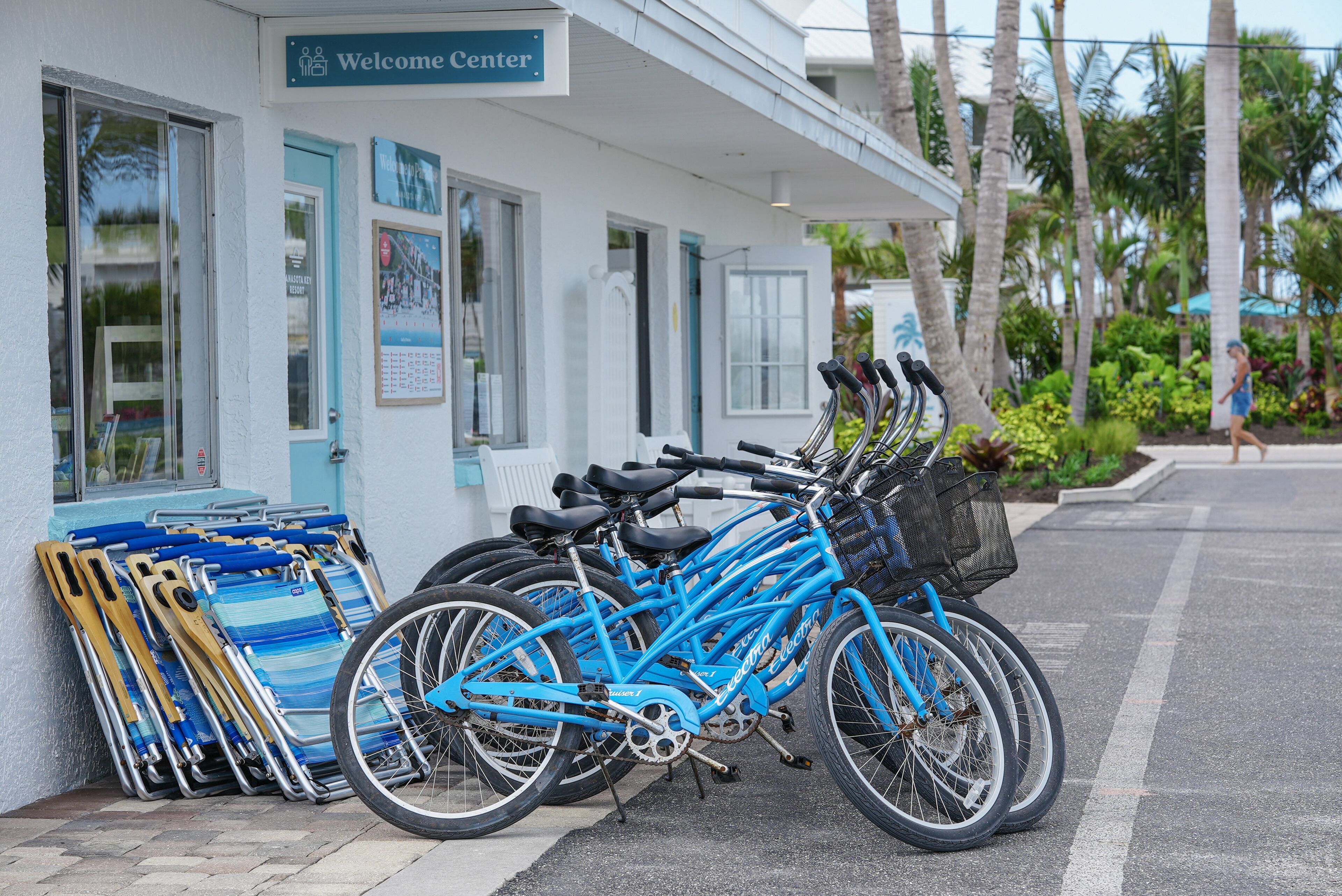 Un centre d’accueil avec une rangée de vélos et de chaises de plage à l’extérieur.