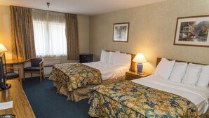 Une chambre d’hôtel avec deux lits, un bureau, une chaise et une fenêtre avec des rideaux.