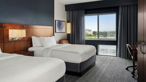 A hotel room with two beds, a large window with a view, a desk, and a chair. - Courtyard by Marriott Evansville East (Evansville)