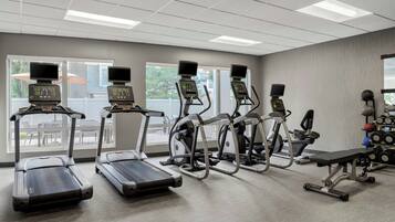 A gym with treadmills, elliptical machines, and weightlifting equipment.