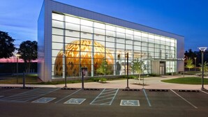A modern building with a large glass facade and a spherical structure inside. - Courtyard by Marriott Evansville East (Evansville)