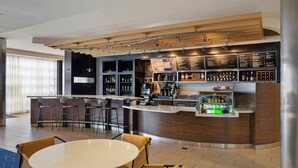 Un área de bar moderna con mostrador, asientos y una pizarra de menú.