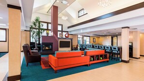 Un hall d’entrée spacieux avec une cheminée, des fauteuils confortables et un coin bar.