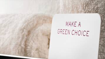 A sign with the text "MAKE A GREEN CHOICE" in a room with a soft, textured background.