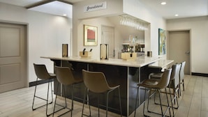 A modern kitchen with a bar area, bar stools, and a sign reading "Grandstand". - Residence Inn San Diego Del Mar (San Diego)