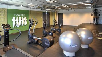 A gym with cardio machines, a treadmill, and exercise balls.