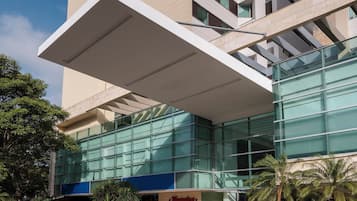 A hotel with a modern design, featuring a prominent 'Champion' sign and a large glass entrance.
