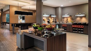 Una cocina moderna con una isla central, zona de bar y diversos electrodomésticos.