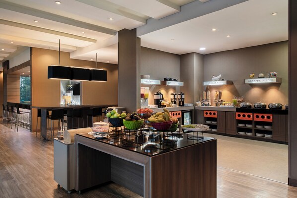 A modern kitchen with a central island, bar area, and breakfast buffet. - Hampton by Hilton Barranquilla (Barranquilla)