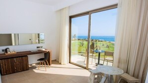A balcony with a view of the ocean and a dining area with a table and chairs. - Amphora Hotel & Suites (Paphos)