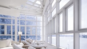 A spa area with sun loungers, large windows, and a view of a body of water. - Park Hyatt Busan (Busan)