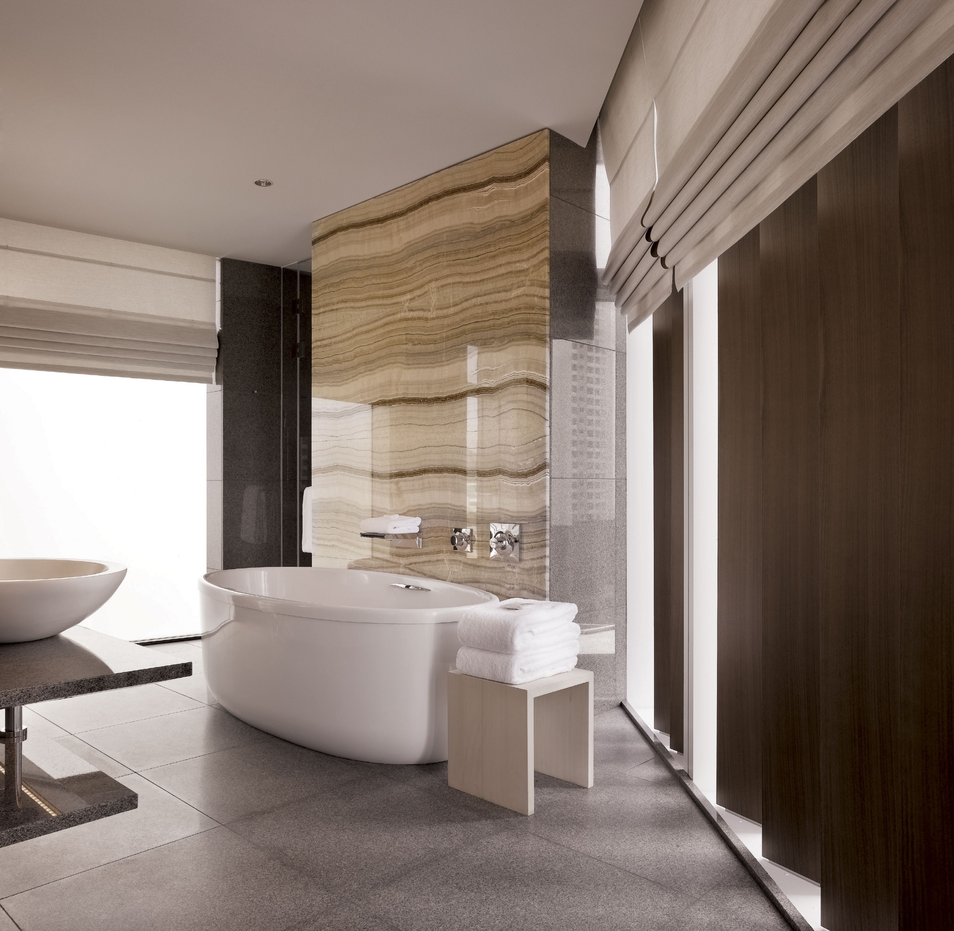 A modern bathroom with a freestanding bathtub, a large mirror, and a vanity with a sink.