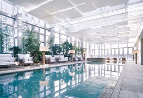 Una piscina techada, sillones reclinables de piscina