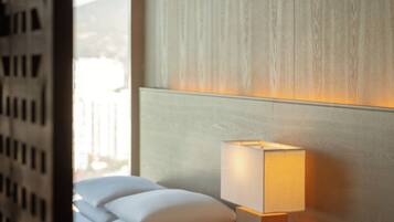 A hotel room with a bed, two bedside tables, a lamp, and a window.