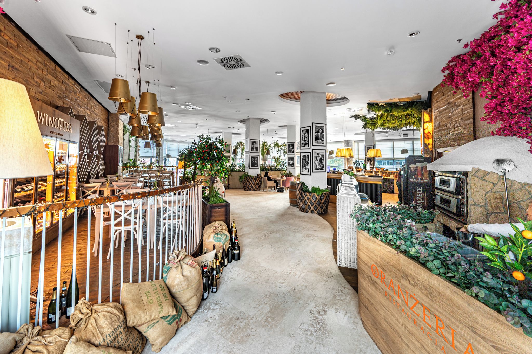 A spacious interior with a central walkway, seating areas, and a bar area with a pizza oven.