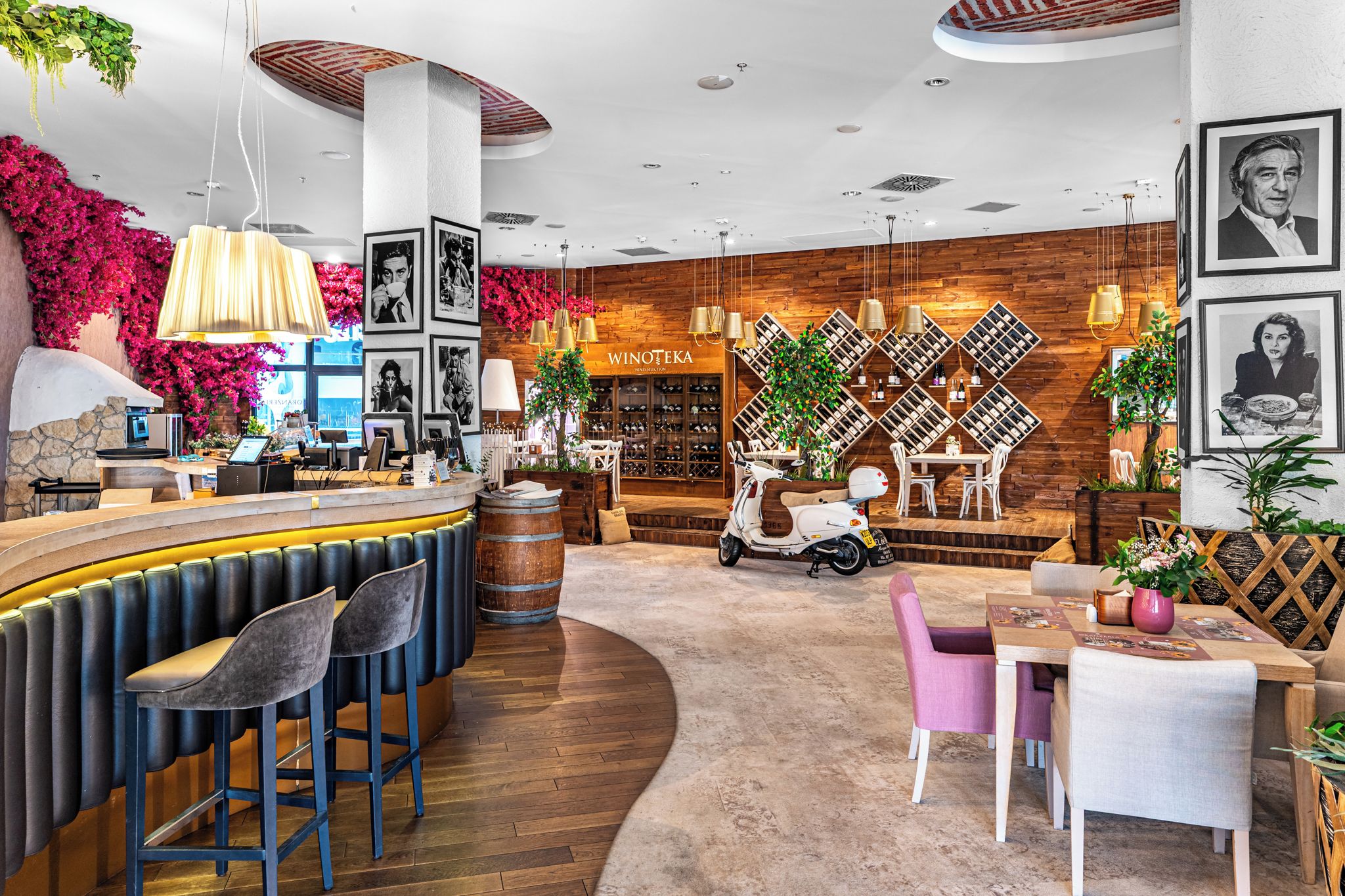 A bar area with stools, a counter, and a wine display.