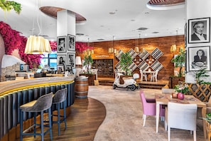 A bar area with stools, a counter, and a wine display. - Hotel Rzeszów (Rzeszów)