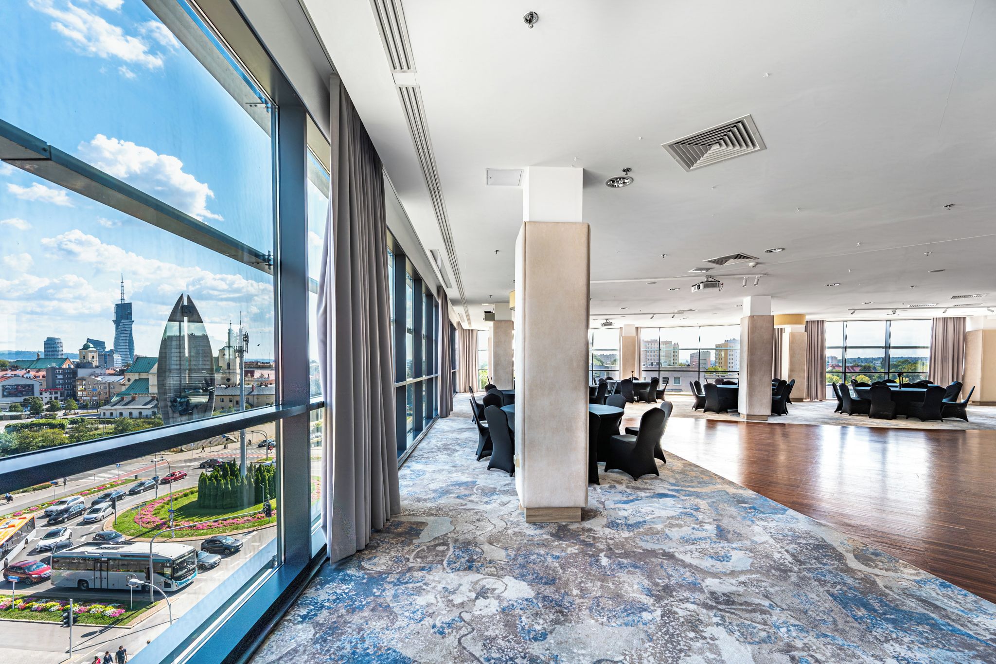 A spacious office with large windows, modern furniture, and a city view.
