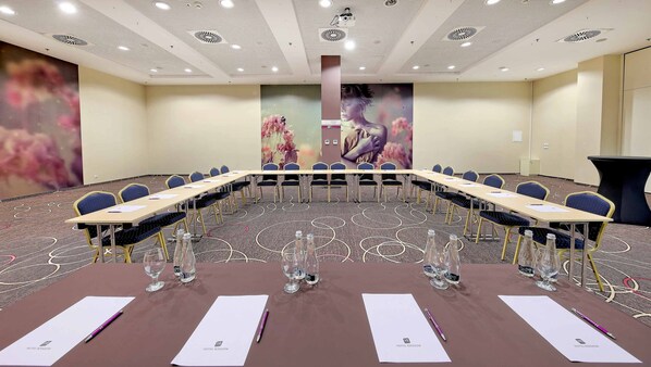 A conference room with a long table, chairs, and water bottles.