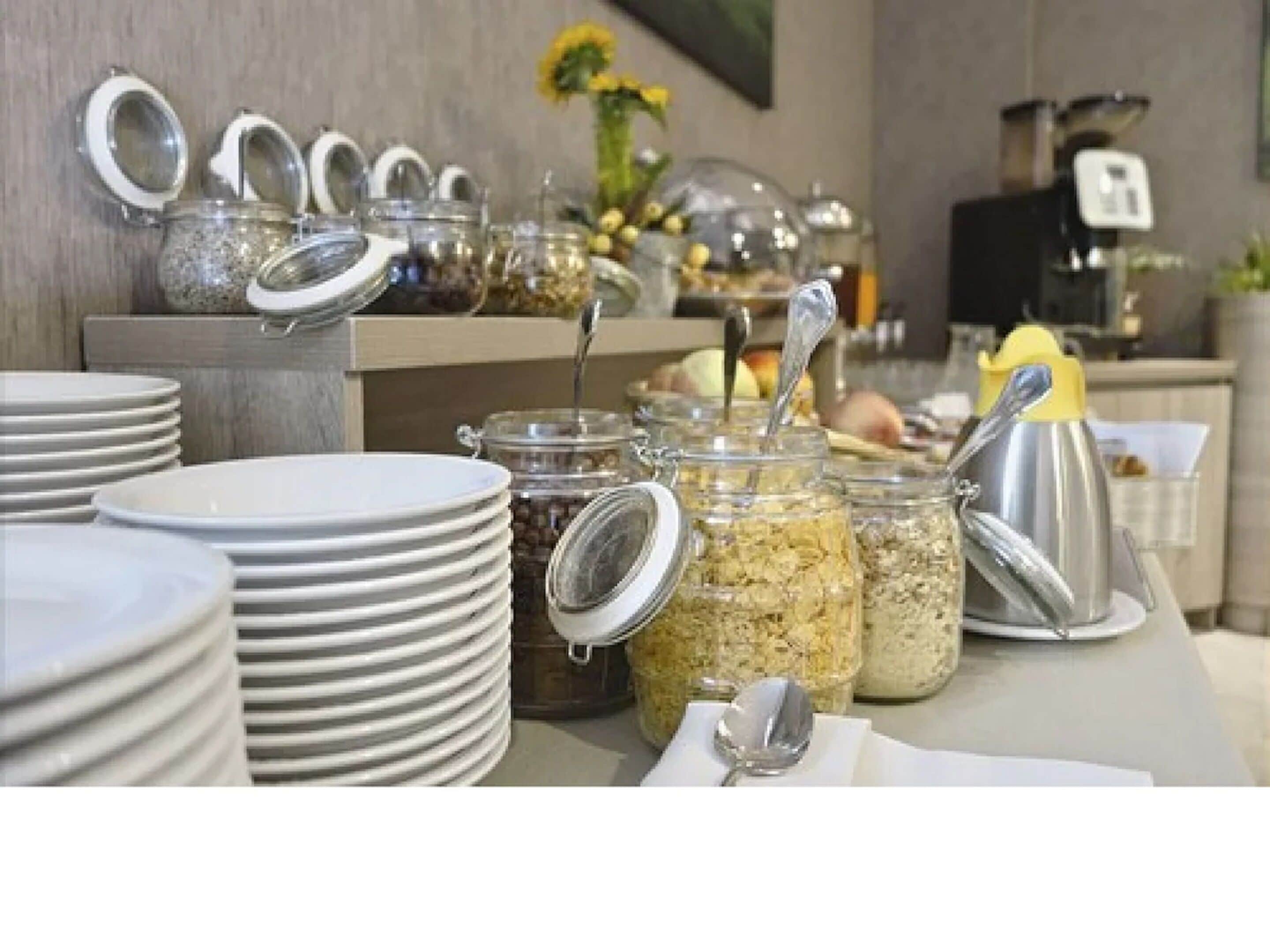 Ein reichhaltiges Buffet mit gestapelten Tellern, Gläsern voller Speisen und Besteck.