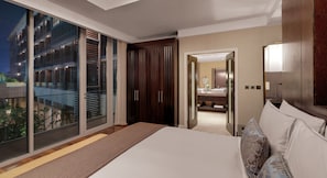 Une chambre d’hôtel moderne dotée d’un grand lit, d’un dressing et d’une porte-fenêtre coulissante donnant sur un balcon extérieur.