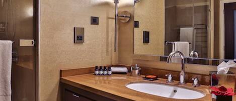 A hotel bathroom with a large sink, mirror, and towel rack.