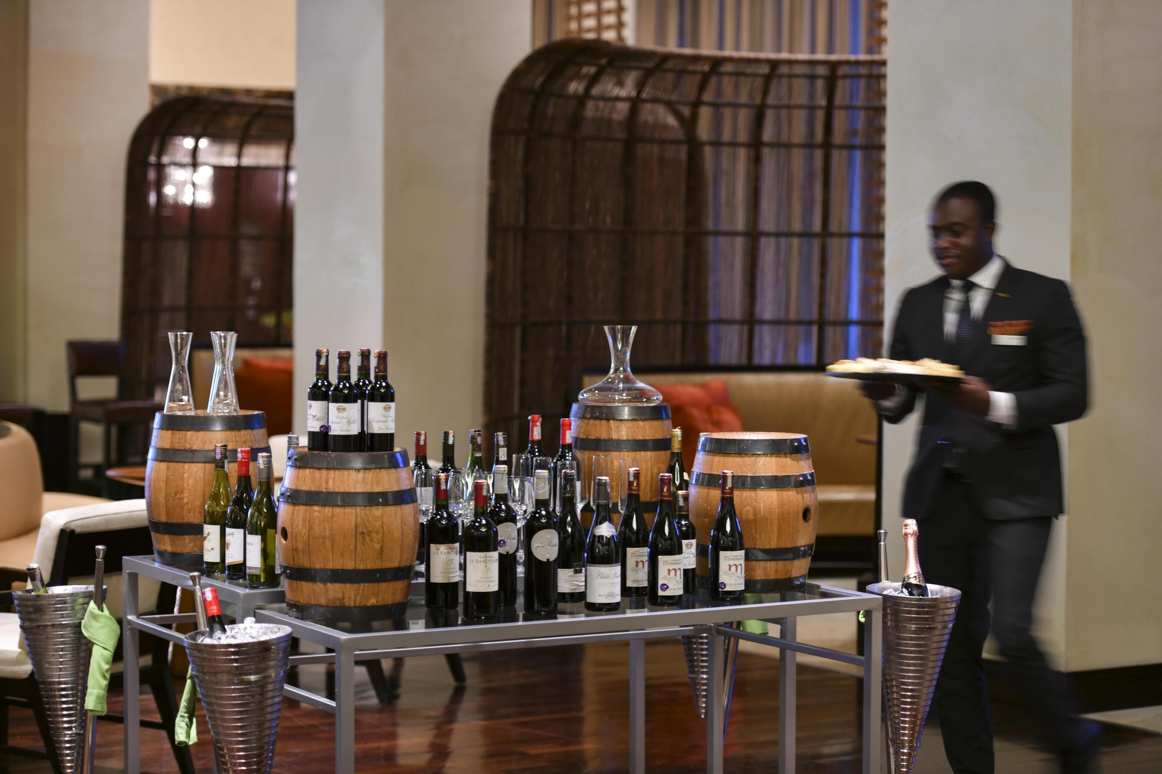 A wine display with bottles and barrels in a hotel lobby.