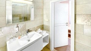 A bathroom with a large mirror, two sinks, and a shower. - Park Hotel (Dolny Kubin)